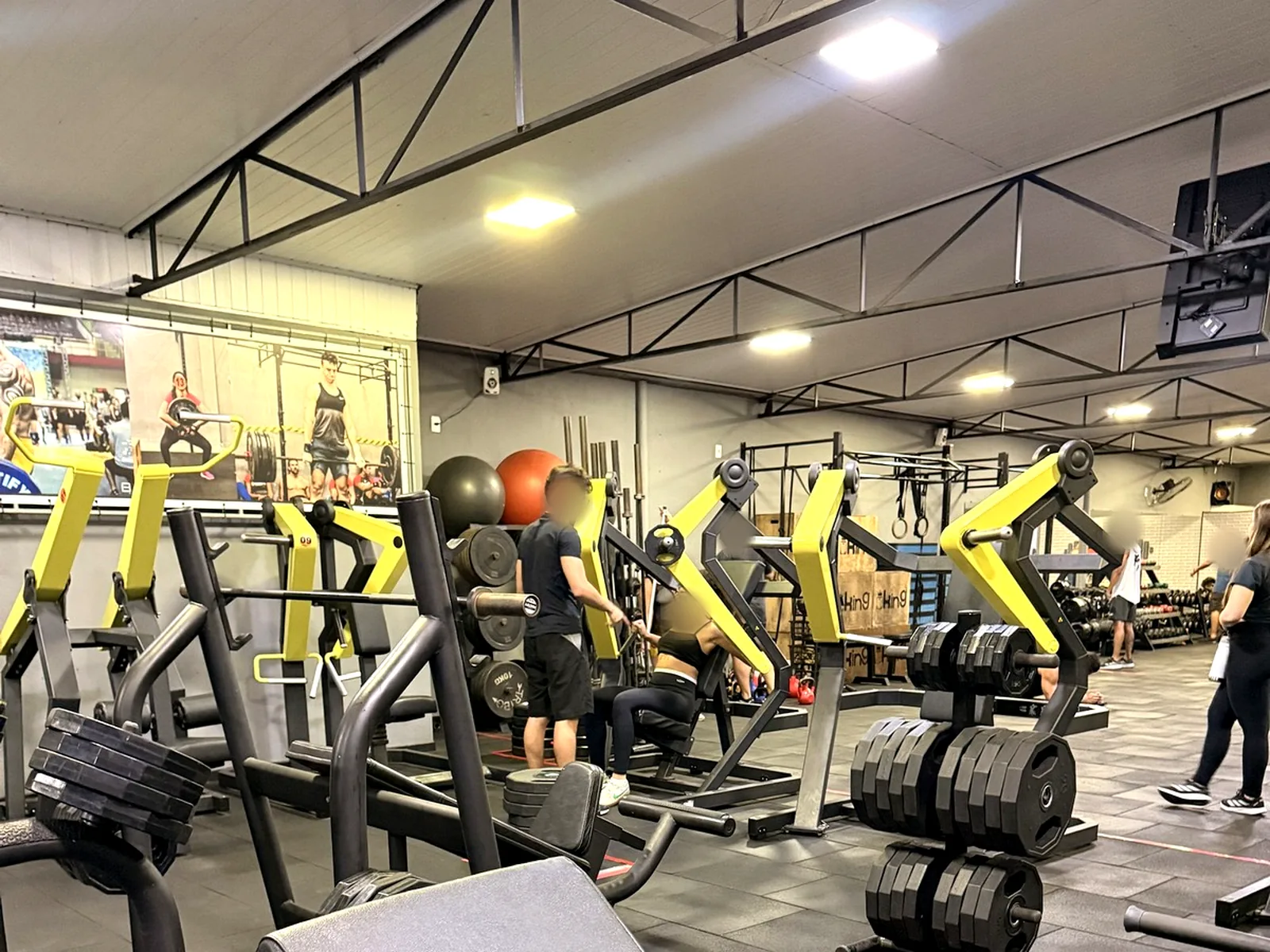 Área de musculação com máquinas novas e pé-direito alto